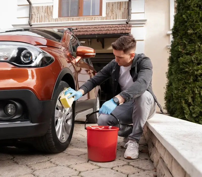 Lavage auto à domicile Castelnaud-de-Gratecambe : professionnel intervenant sur un véhicule